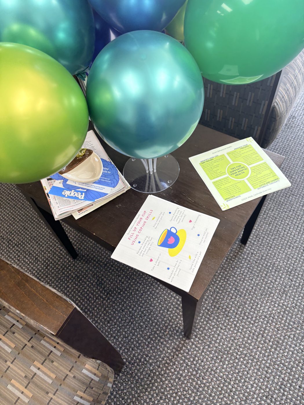 Mental health takeaway cards on a side table: Fill Up Your Cup Using Coping Skills and Tips for Supporting Your Mental Health