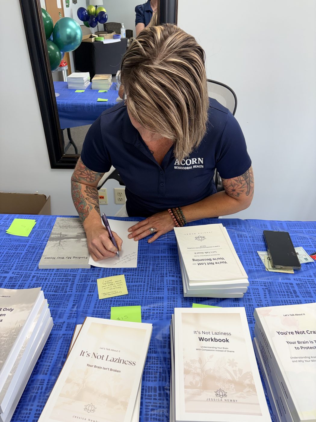 Jessica Newby signing a copy of Finding My Way Home at the book table